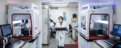 female researcher walking through lab with test samples