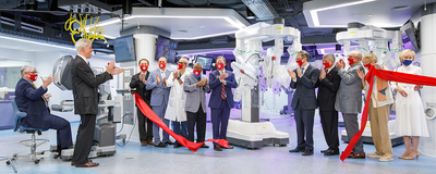 administrators in masks cut red ribbon in surgical center