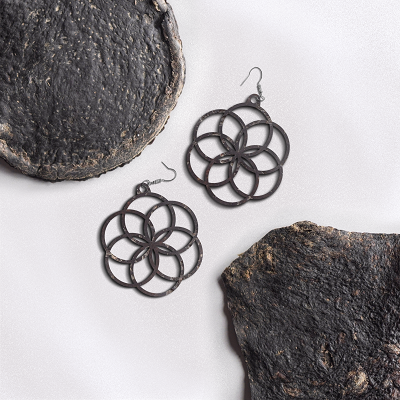 Samples of Pyrus, made out of kombucha waste, with geometric dangly earrings made from the invention