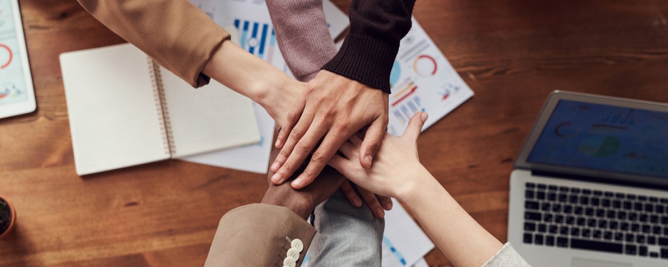 people joining hands at a business table